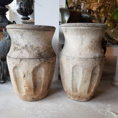 two cement pots sitting next to each other