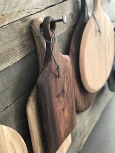 three wooden cutting boards hanging on a wall