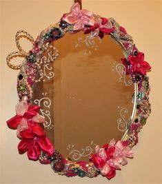 a mirror with pink flowers and bows on it