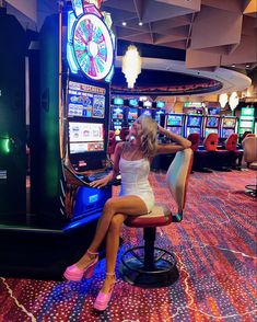 a woman sitting on a chair in front of a slot machine at a gambling center