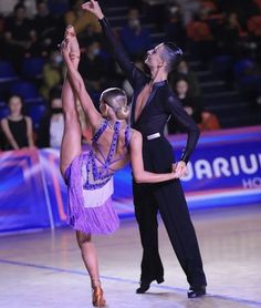 two people are performing on the floor in front of an audience at a dance competition