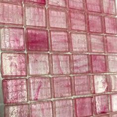 pink glass tiles on the wall in a bathroom