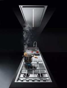 a stove top with steam coming out of it's burners and cooking utensils