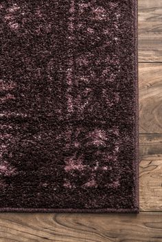 a purple rug on top of a wooden floor next to a wood flooring board