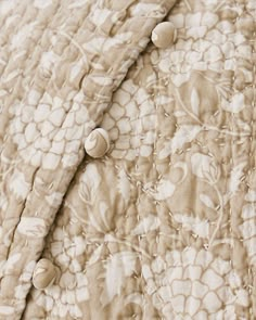 an up close view of a bed with buttons on it's cover and sheets