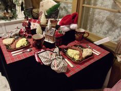 the table is set for christmas dinner with red and white plaid napkins on it