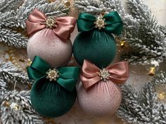 three green and pink ornaments with bows on them