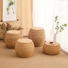 three woven stools are sitting on the floor in front of a window with curtains