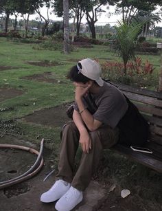 a person sitting on a bench with their head in his hands