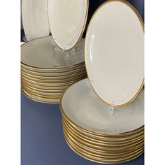 a stack of white and gold dinner plates