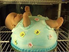 a baby laying on top of a cake in an oven