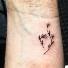 a small flower tattoo on the wrist