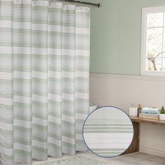 a bathroom with a shower curtain and rug on the floor next to it is shown