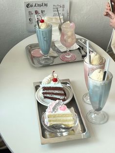 two trays filled with cakes and drinks on top of a table