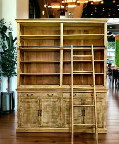 an old wooden bookcase with two ladders on it in the middle of a room