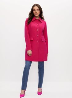 a woman wearing a pink coat and jeans