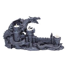 a statue of a castle with two candles in the center and a dragon on top