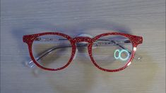 a pair of glasses sitting on top of a wooden table