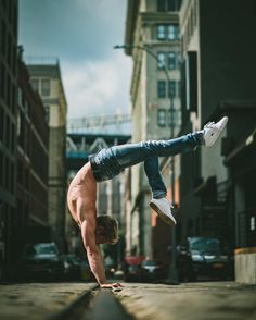 a man doing a handstand on the street