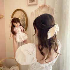 a woman is looking at her doll in the mirror