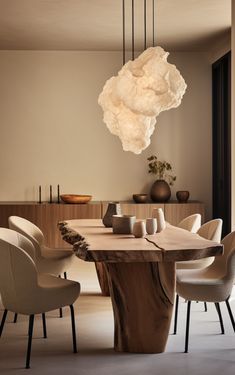 a dining room table with chairs and a light fixture hanging from the ceiling