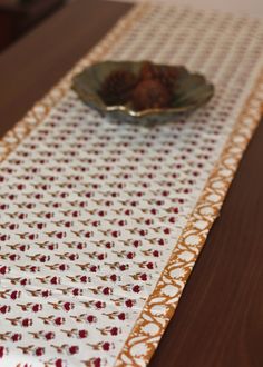 a table with a bowl of food on top of it next to a cloth runner