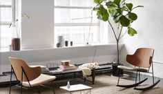 a living room filled with furniture and a tree in the middle of it's floor