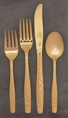 four forks, two spoons and one knife are on a table with a black background