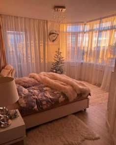 a bedroom with a bed, lamps and curtains on the window sill in front of it