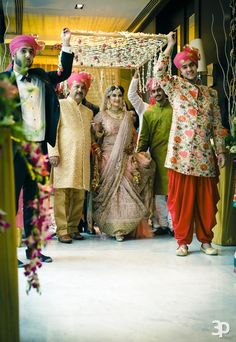 a group of people standing next to each other in front of a doorway with flowers