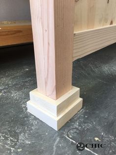 a close up of a wooden post on the ground near a bed headboard and foot board