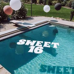 a swimming pool with balloons floating around it and the words sweet sixteen written in white