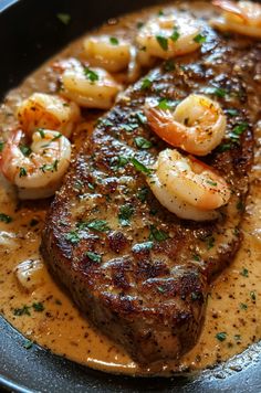 steak with shrimp and shrimp on top in a skillet