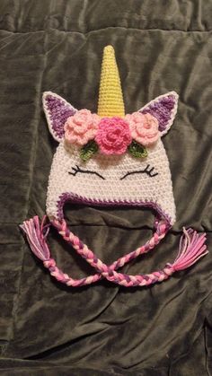 a crocheted unicorn hat with flowers on it