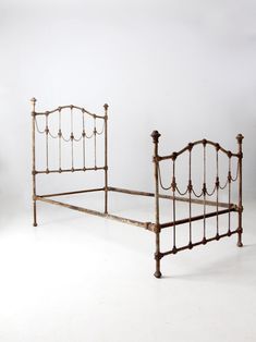 an old iron bed frame with no headboard and foot board is shown against a white background