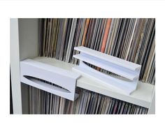 two white shelves with vinyl records on them