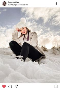 a woman is sitting in the snow and smiling