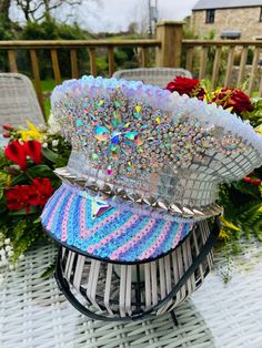 two hats sitting on top of each other on a table with flowers in the background