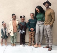 a family poses for a photo in front of a wall