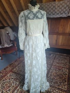 Here is an interesting dress presented by Victoria Royal "made in British Crown Colony, Hong Kong" in 1968.  Ivory chantilly lace over silk organza over lightweight taffeta lining. The silk layer has frayed a bit and needs to be trimmed and rehemmed, if it bothers you. It can not be seen from the outside of the garment. I love the ruffled lace stand-up collar that ties in a bow at the nape. The spaghetti strap top is not attached to the last for nice movement. Natural waist with a detachable satin crepe tie belt which can be switched out or tied in the front...whatever you want! Long-sleeved, sheer lace with a ruffled cuff. The hem is finished off with a 4" lace flounce.  This dress has no train. Measurements (tagged a vintage size 12) = Bust- 36" Waist- 26" Hips- 37" Length from shoulder Vintage Lace Gowns, Spaghetti Strap Top, Chantilly Lace, Silk Organza, Strap Top, Lace Gown, Belt Tying, Vintage Lace, Sheer Lace