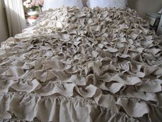 an unmade bed with ruffled sheets and pillows