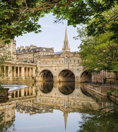 an old bridge is reflected in the water