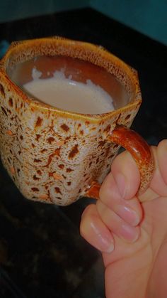 a person holding a hot beverage in their hand