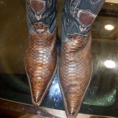 a pair of cowboy boots on top of a glass table