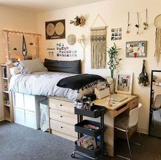 a bedroom with a bed, desk and various pictures on the wall above it is decorated with string lights