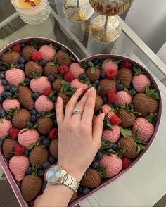 a heart shaped box filled with lots of chocolate covered strawberries and raspberries