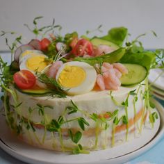 a cake decorated with cucumbers, tomatoes and eggs