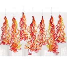 red and yellow streamers hanging from the ceiling in front of a white wall with windows