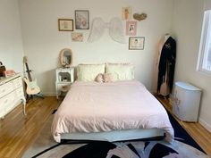 a bedroom with white walls and wooden floors