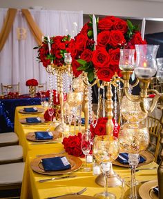 a table set with red roses and candles for a formal dinner or party, ready to be served